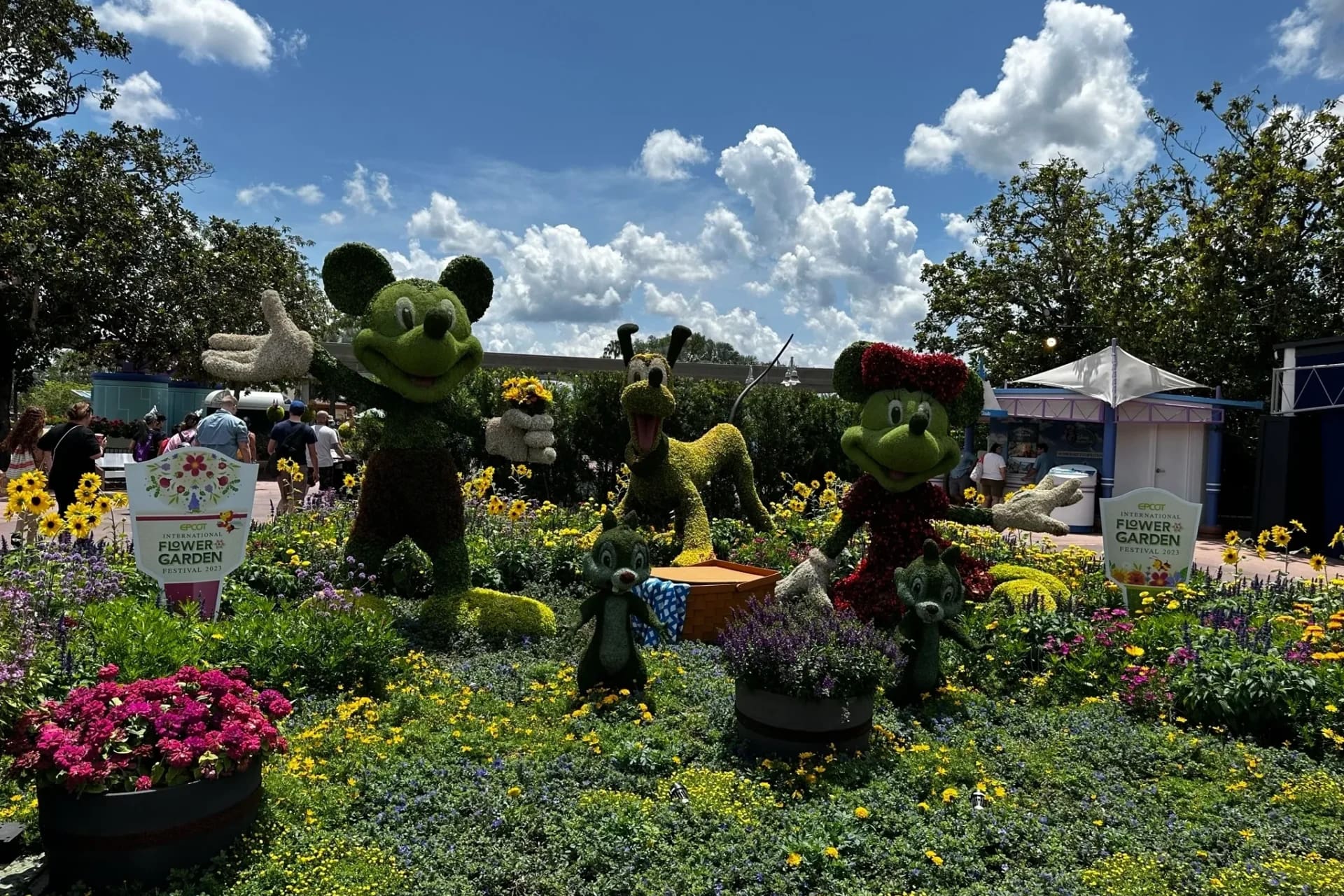 A group of mickey mouse and minnie mouse statues in the grass.